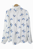 Blusa blanca con bordado azul y cuello alto para mujer 3025-AZ