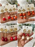 Aretes colgantes vintage con flor dorada y cuentas rojas pen899